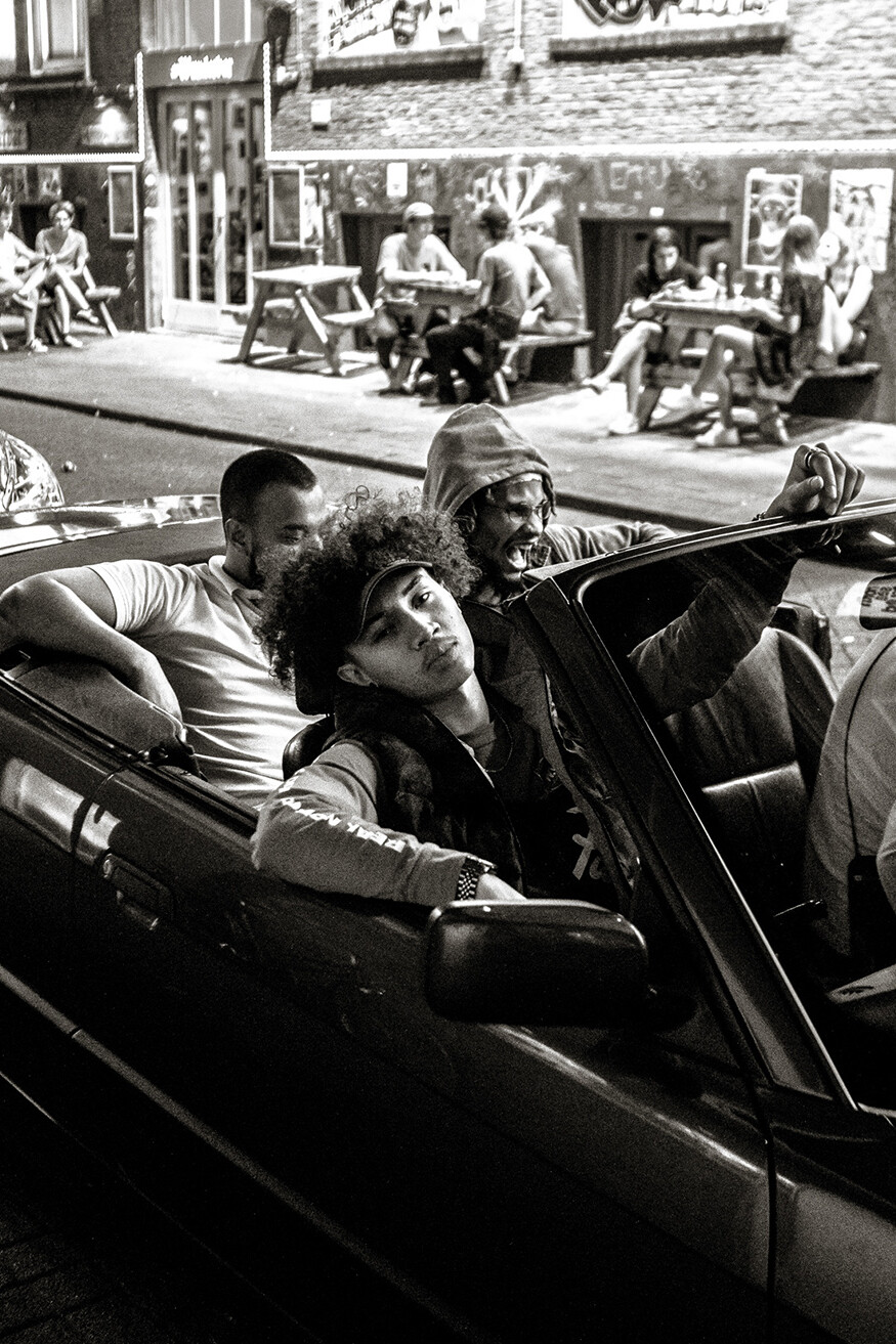Vier jongemannen die gaan stappen en in een cabrio zitten. Gefotografeerd in 2018 door Stacii Samadin in een 'moeilijke' buurt in Rotterdam.